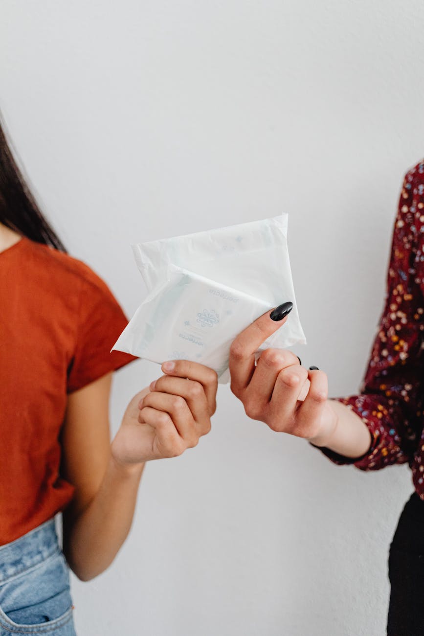 close up shot of two people holding sanitary napkins in a pack